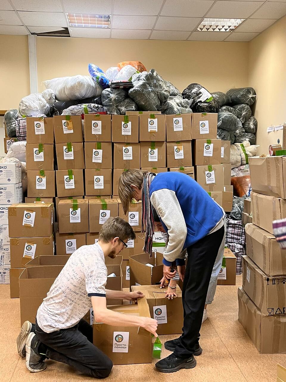 Волонтеры упаковывают гуманитарную помощь на складе. Фото: предоставлено некоммерческой организацией "Ясное дело". 